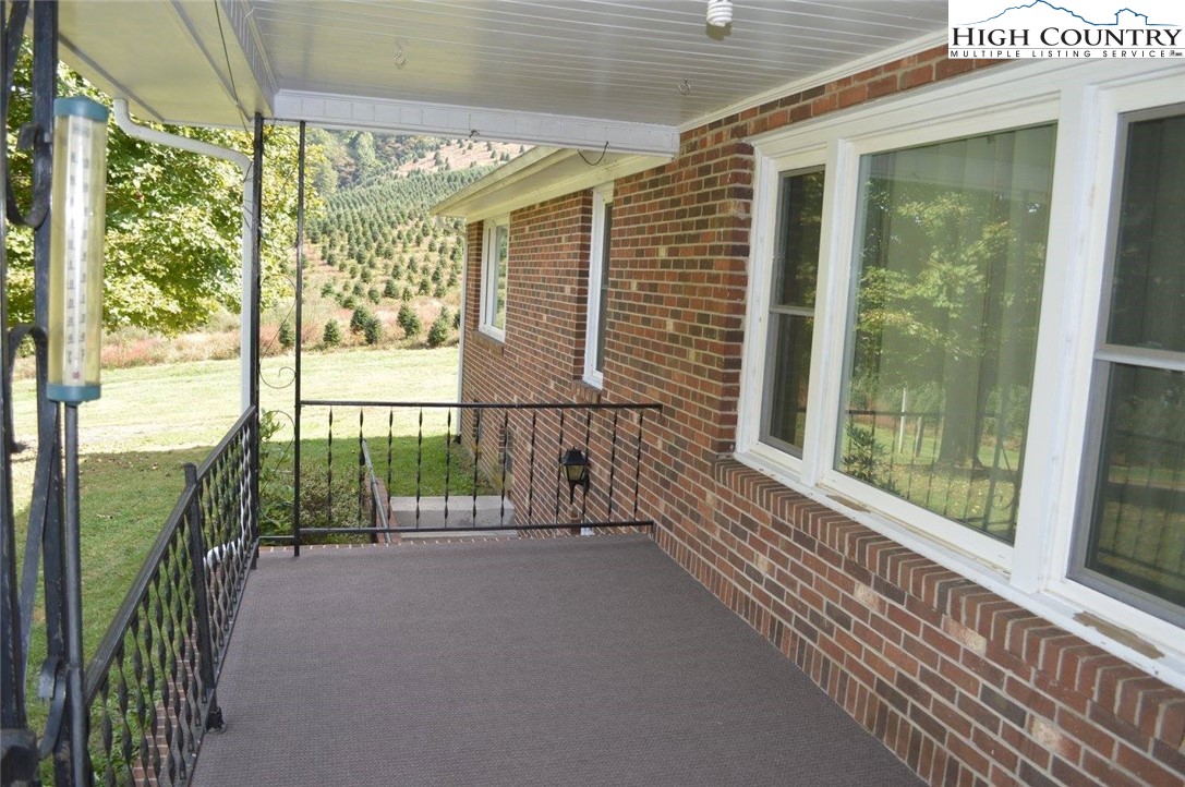1681 Big Windfall Road Lansing, NC 28643 - Photo 3 of 30 a view of a balcony with floor to ceiling windows with wooden floor