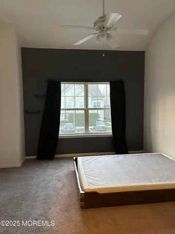 a bed sitting in a spacious bedroom next to a window