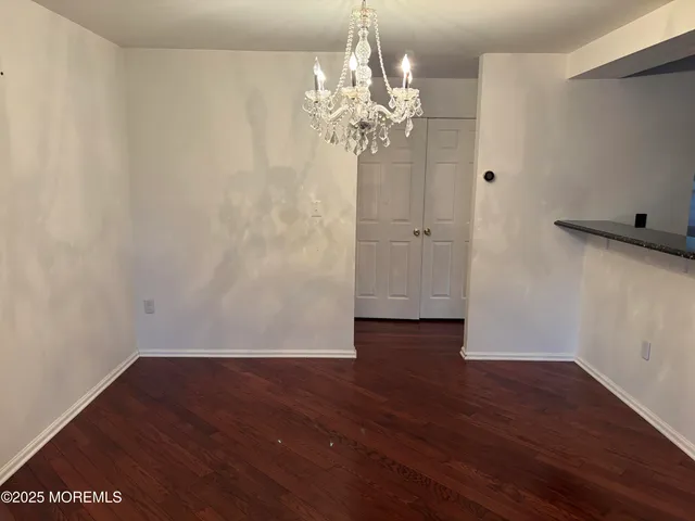 a view of a room with wooden floor and chandelier