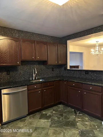 a kitchen with stainless steel appliances granite countertop a sink stove and cabinets