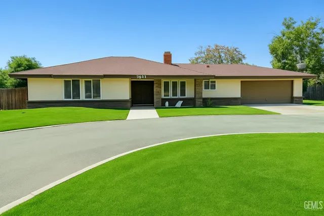 a front view of a house with a yard and potted plants