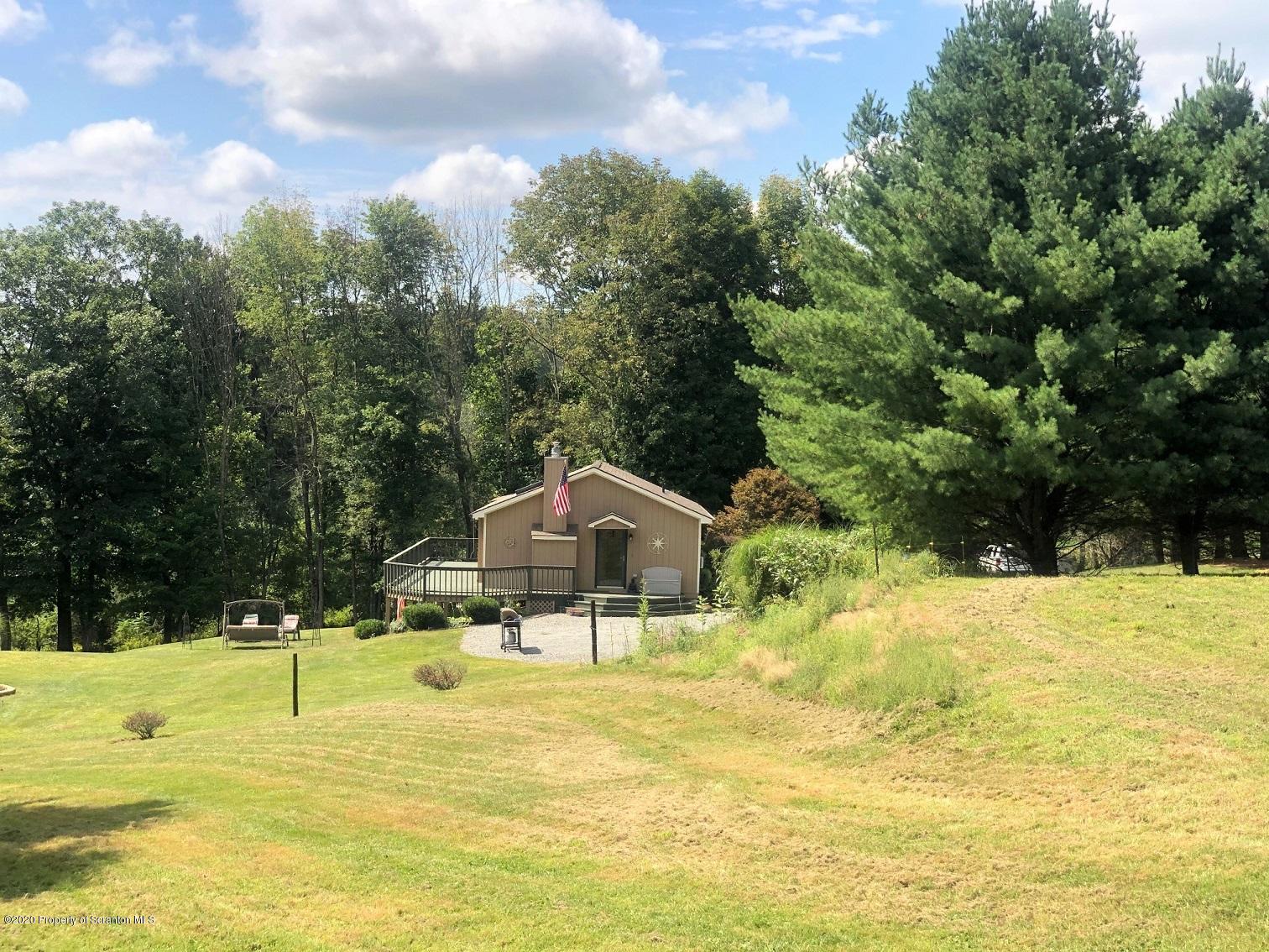 164 Halstead Road Union Dale, PA 18470 - Photo 1 of 36 a swimming pool with lawn chairs under an umbrella