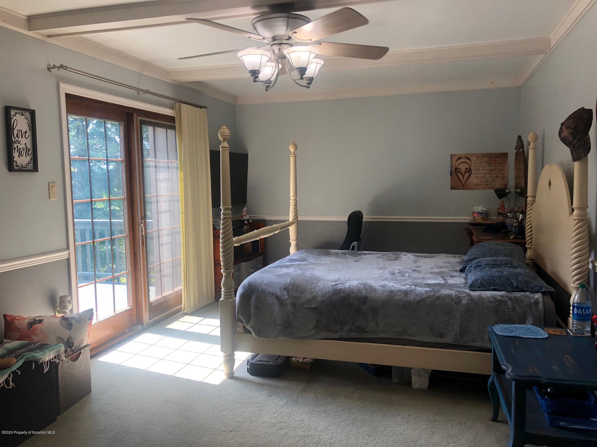 164 Halstead Road Union Dale, PA 18470 - Photo 12 of 36 a bedroom with a bed and a chandelier