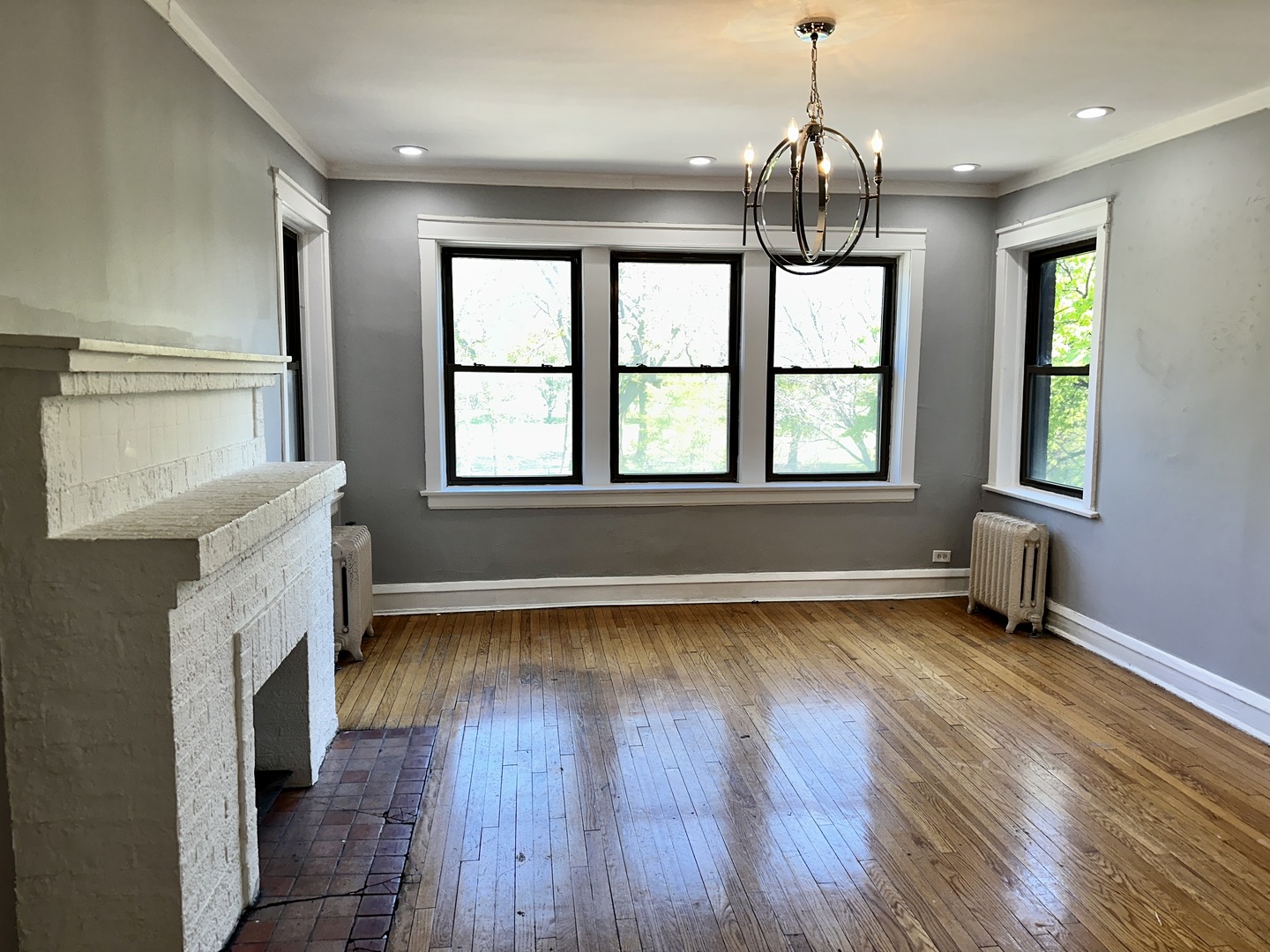 2207 East 67th Street, Unit 2 Chicago, IL 60649 - Photo 2 of 13 a view of an empty room with wooden floor and a window