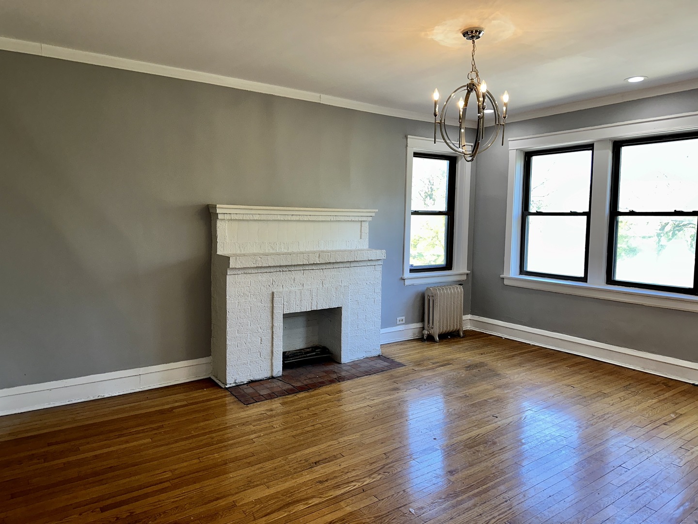 2207 East 67th Street, Unit 2 Chicago, IL 60649 - Photo 3 of 13 an empty room with wooden floor fireplace and windows
