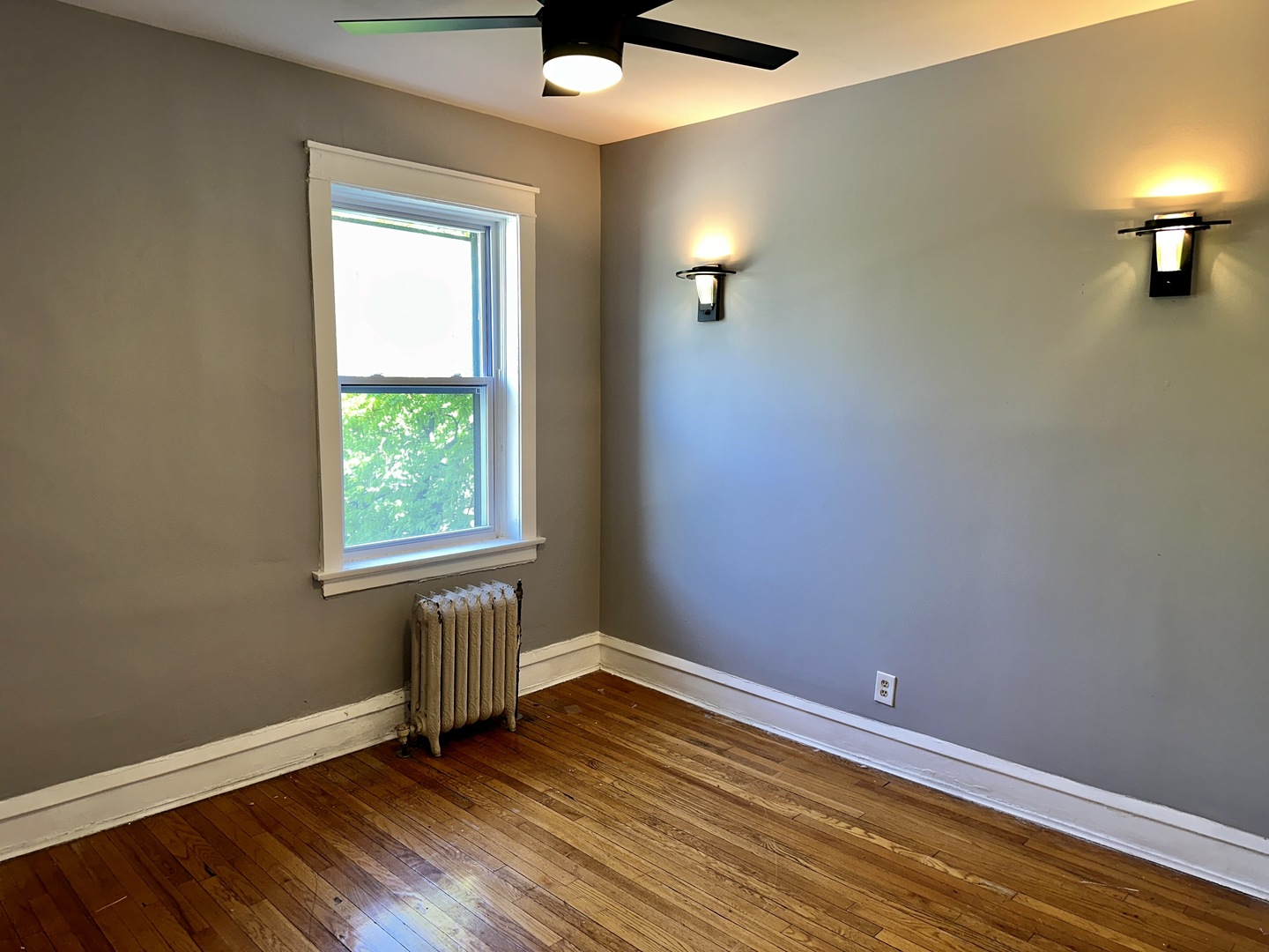 2207 East 67th Street, Unit 2 Chicago, IL 60649 - Photo 5 of 13 an empty room with a window and wooden floor