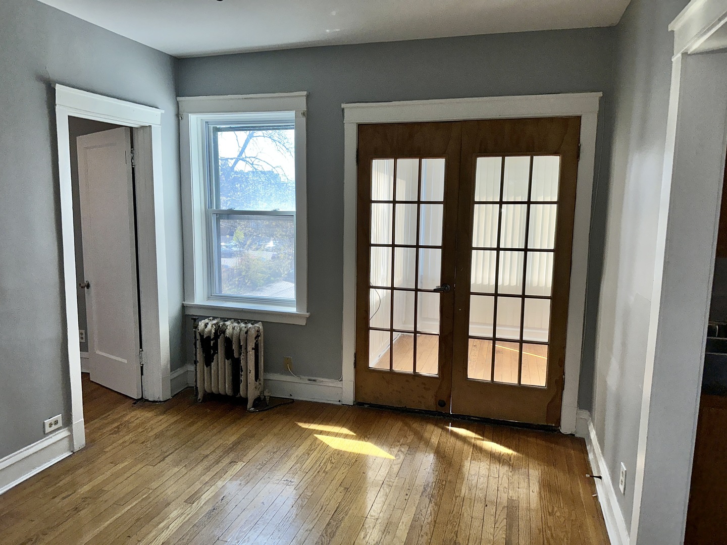 2207 East 67th Street, Unit 2 Chicago, IL 60649 - Photo 6 of 13 an empty room with wooden floor and windows