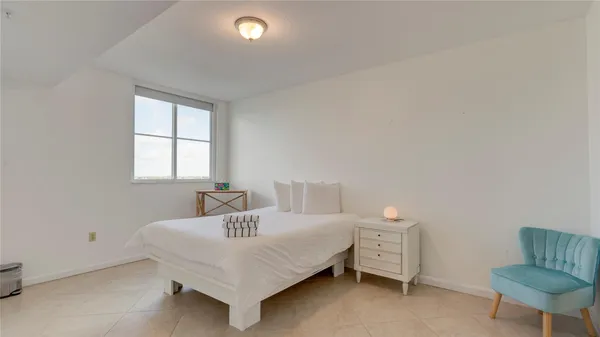 a bedroom with a bed and a chair
