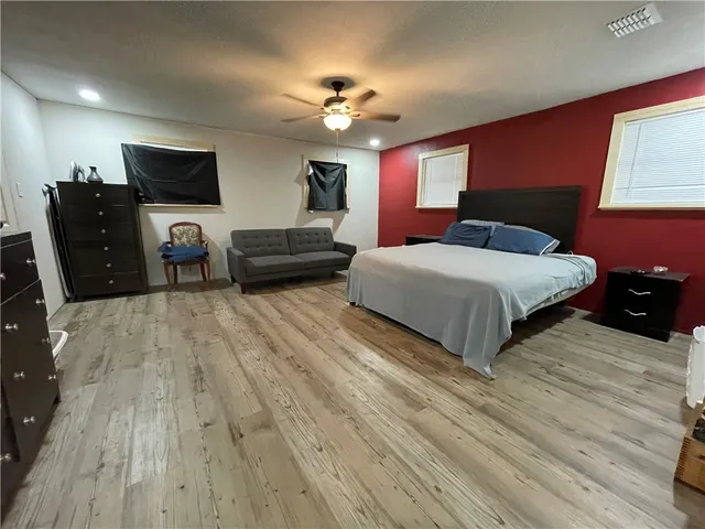 a spacious bedroom with a bed and a chandelier