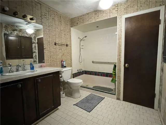 a bathroom with a sink a toilet and shower