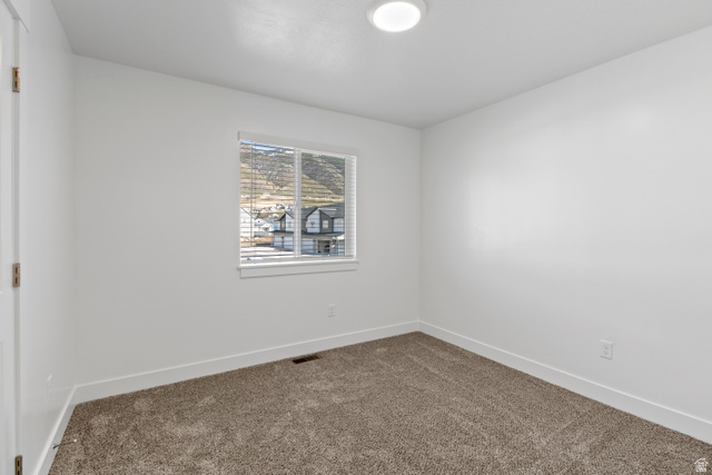 1271 West 500 South Logan, UT 84321 - Photo 21 of 26 Neutral wall colors with white trim and a single window offering a distant mountain backdrop