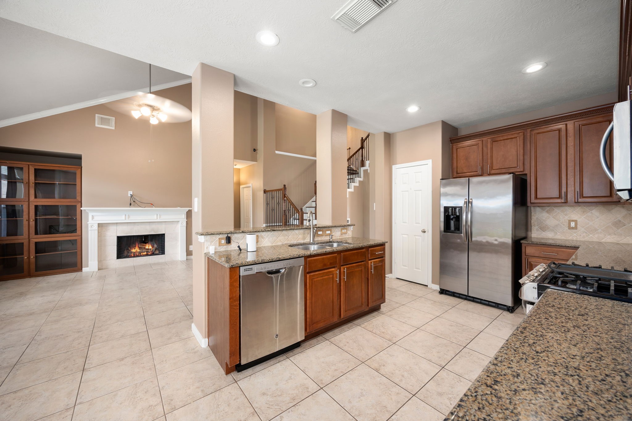 4526 Countrypines Drive Spring, TX 77388 - Photo 20 of 38 Enjoy a commanding view from the heart of the home! The central kitchen island keeps the chef fully connected to the dramatic, vaulted family room and cozy fireplace, making it the perfect hub for entertaining guests.