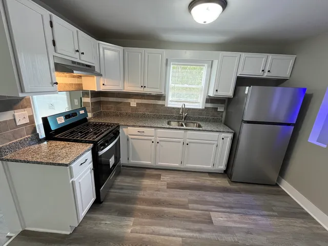 a kitchen with a sink a stove a refrigerator and cabinets
