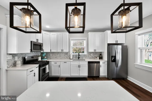 a kitchen with stainless steel appliances granite countertop a refrigerator a stove top oven a sink and dishwasher next to a window