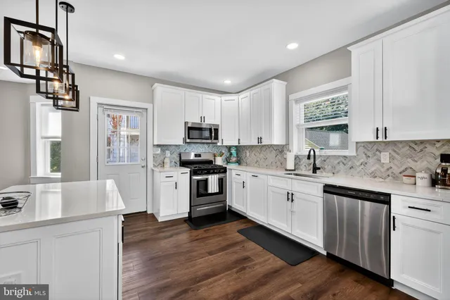 a kitchen with granite countertop white cabinets and white appliances