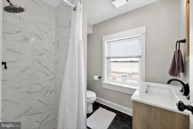 a bathroom with a sink a toilet and a window