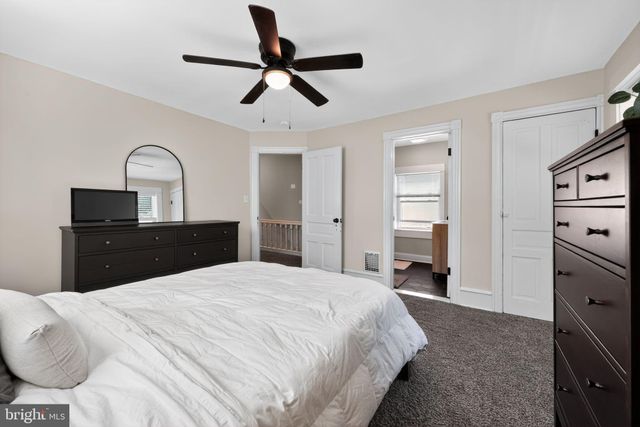 a spacious bedroom with a bed and a dresser