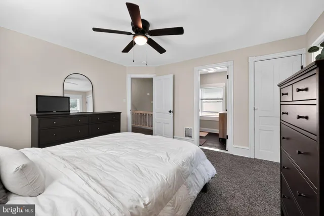 a spacious bedroom with a bed and a dresser