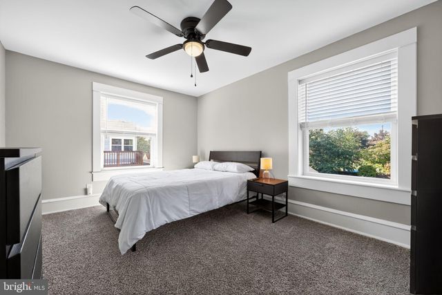 a bedroom with a bed flat screen tv and a large window