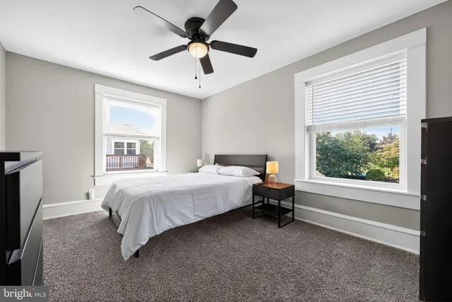 a bedroom with a bed flat screen tv and a large window