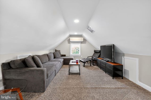 a living room with furniture a flat screen tv and a window