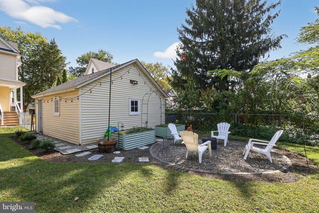 a view of a patio with table and chairs potted plants and large tree