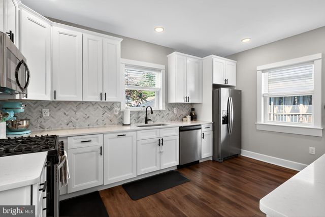 a kitchen with a refrigerator sink and cabinets