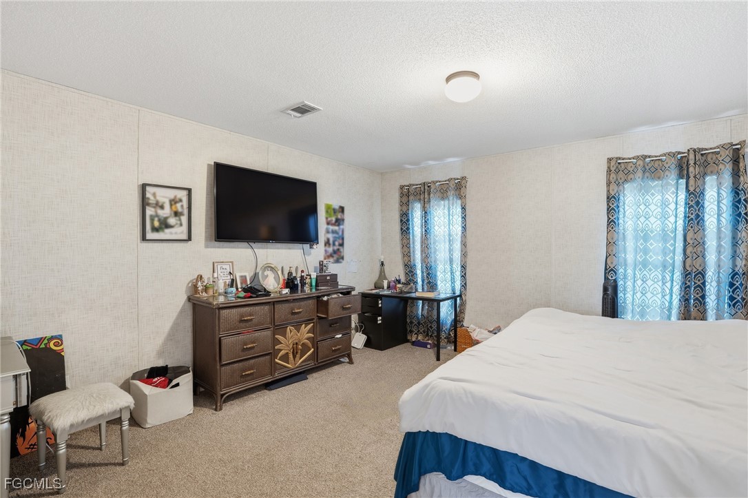 2491 Farrance Court North Fort Myers, FL 33917 - Photo 12 of 26 a bedroom with furniture and flat screen tv