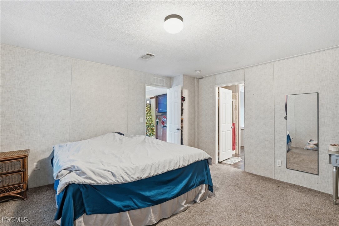 2491 Farrance Court North Fort Myers, FL 33917 - Photo 13 of 26 a bedroom with a bed and a mirror