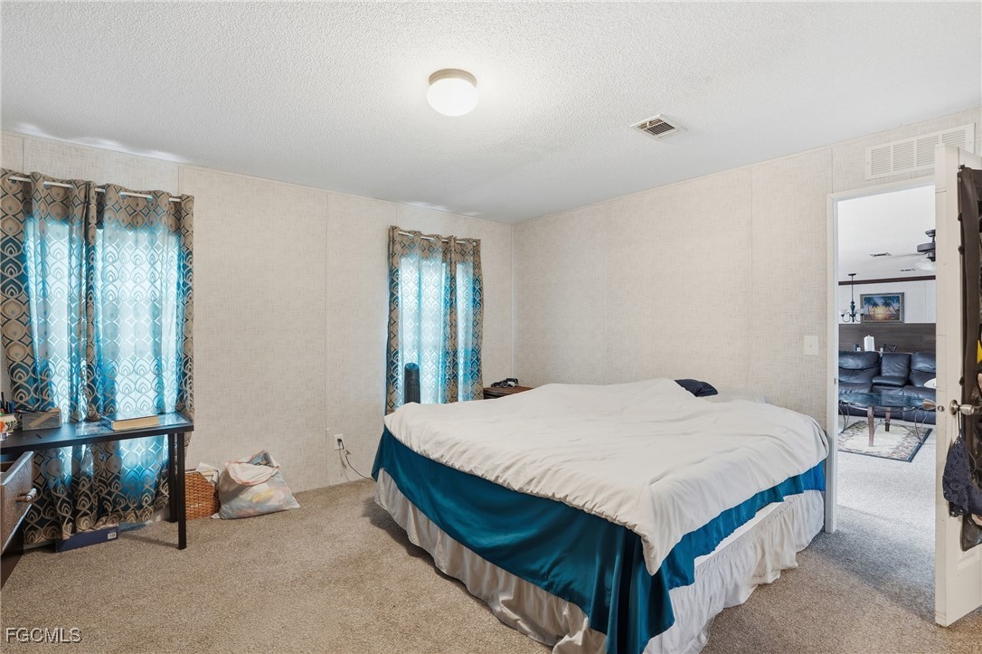 2491 Farrance Court North Fort Myers, FL 33917 - Photo 14 of 26 a bedroom with a bed and a table in it