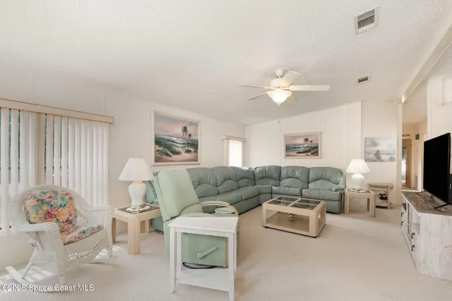 a living room with furniture ceiling fan and a flat screen tv
