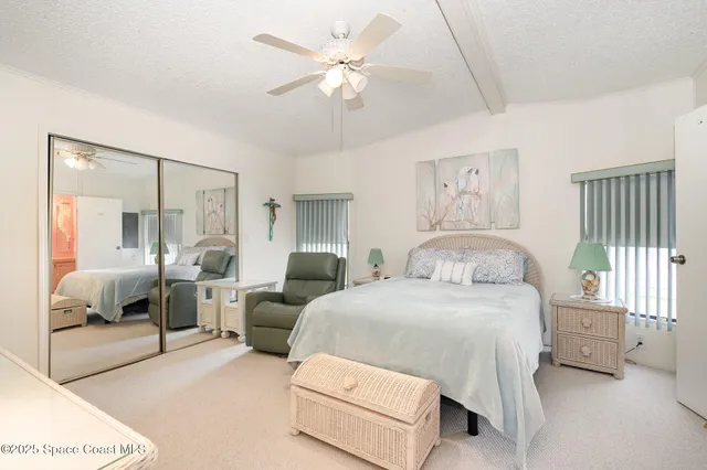 a bedroom with a bed and ceiling fan