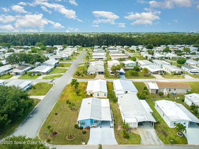 an aerial view of residential houses with outdoor space and trees