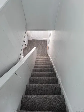 a kitchen with stainless steel appliances a stove a refrigerator a sink a microwave oven and a dining table with wooden floor