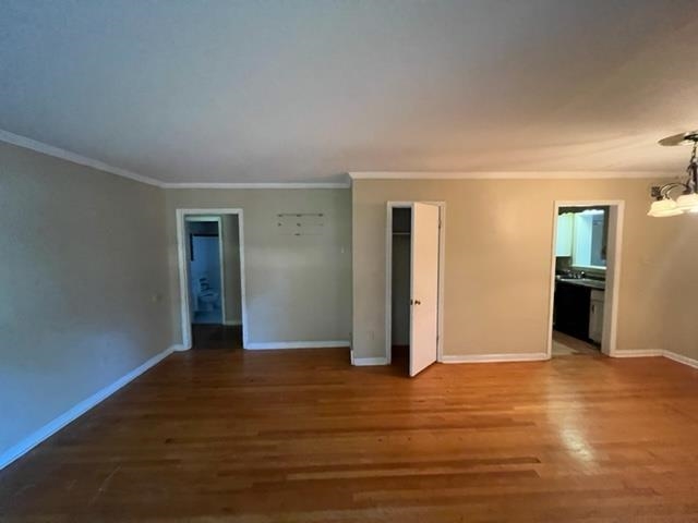 4760 Willow Road Memphis, TN 38117 - Photo 3 of 16 a view of an empty room with wooden floor and a kitchen