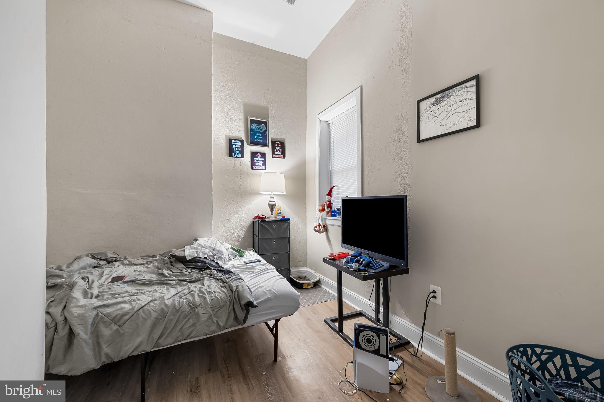 1005 Edmondson Avenue Baltimore, MD 21223 - Photo 13 of 45 a bedroom with bed and a flat screen tv