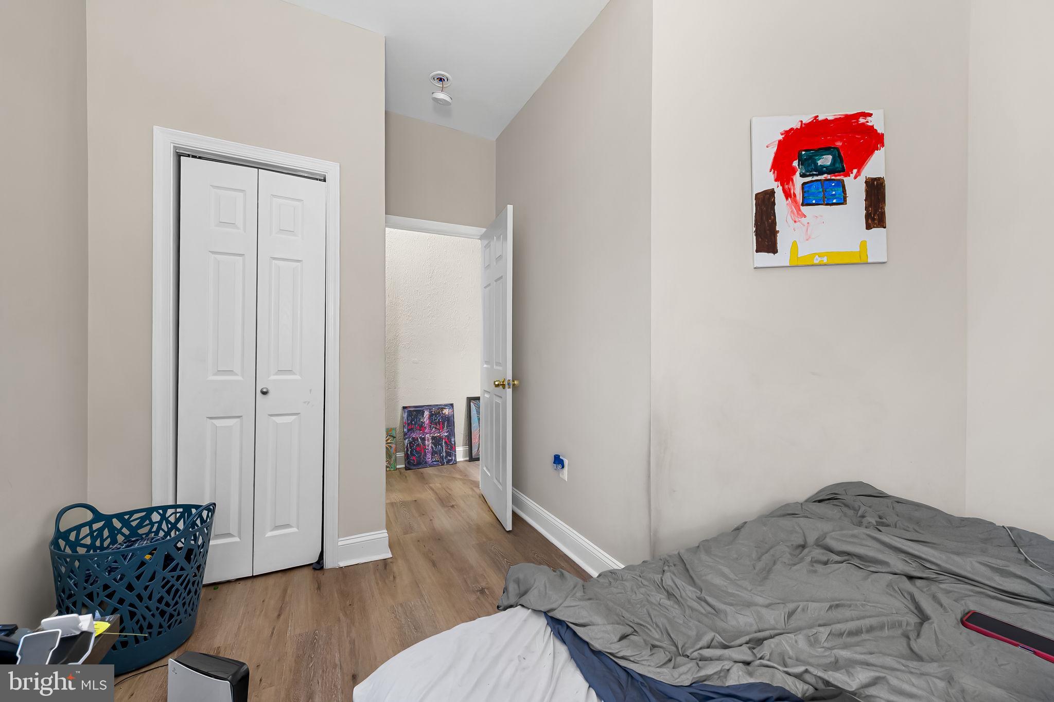 1005 Edmondson Avenue Baltimore, MD 21223 - Photo 14 of 45 a bedroom with a bed and a wooden floor