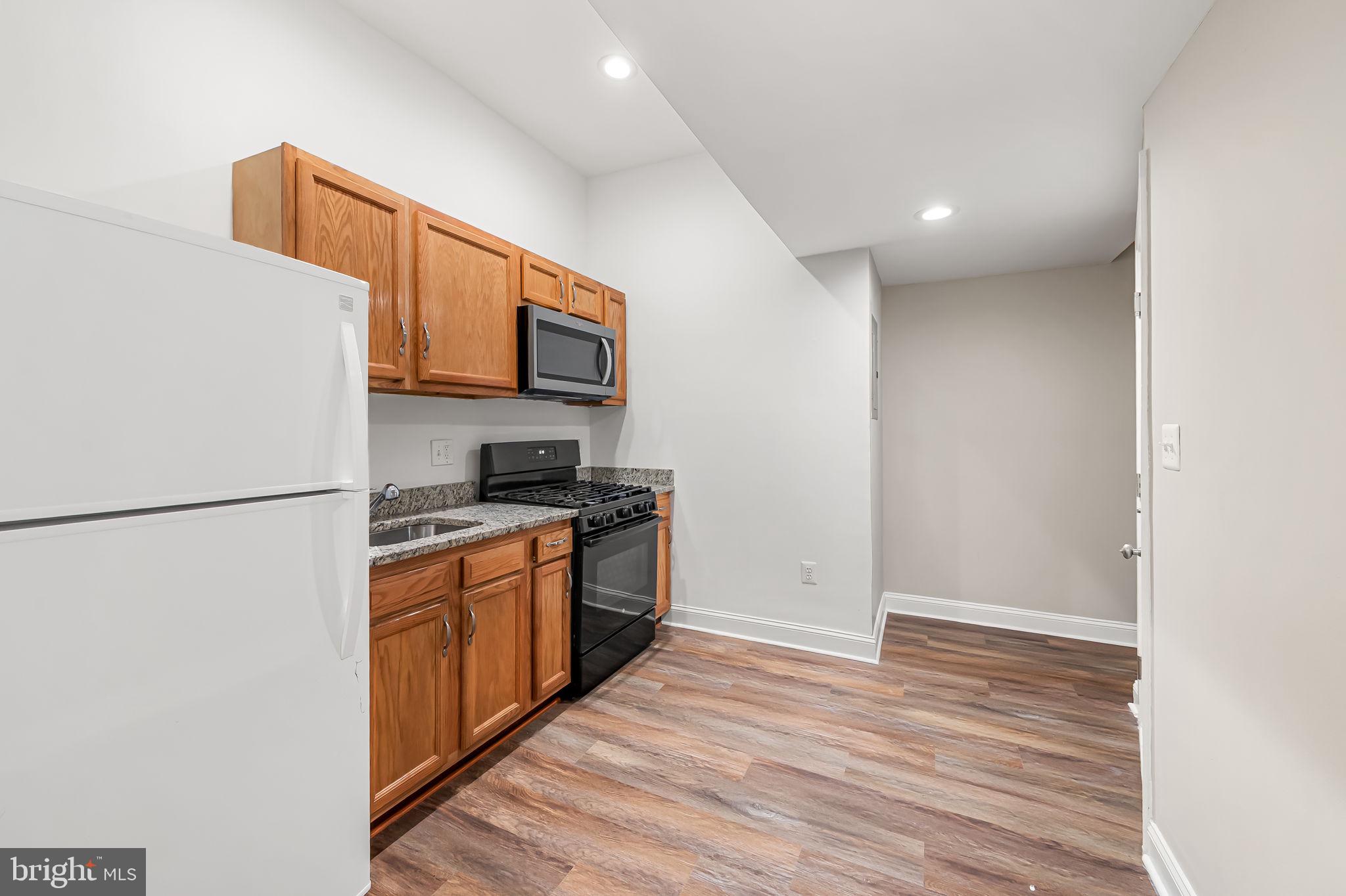 1005 Edmondson Avenue Baltimore, MD 21223 - Photo 20 of 45 a kitchen with stainless steel appliances granite countertop a refrigerator sink and stove