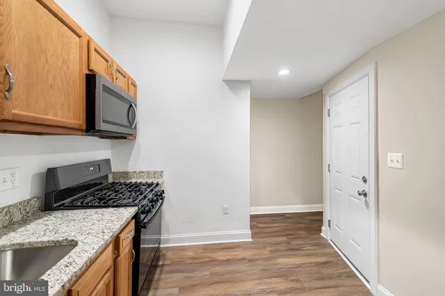 a kitchen with a sink stove top oven and cabinets