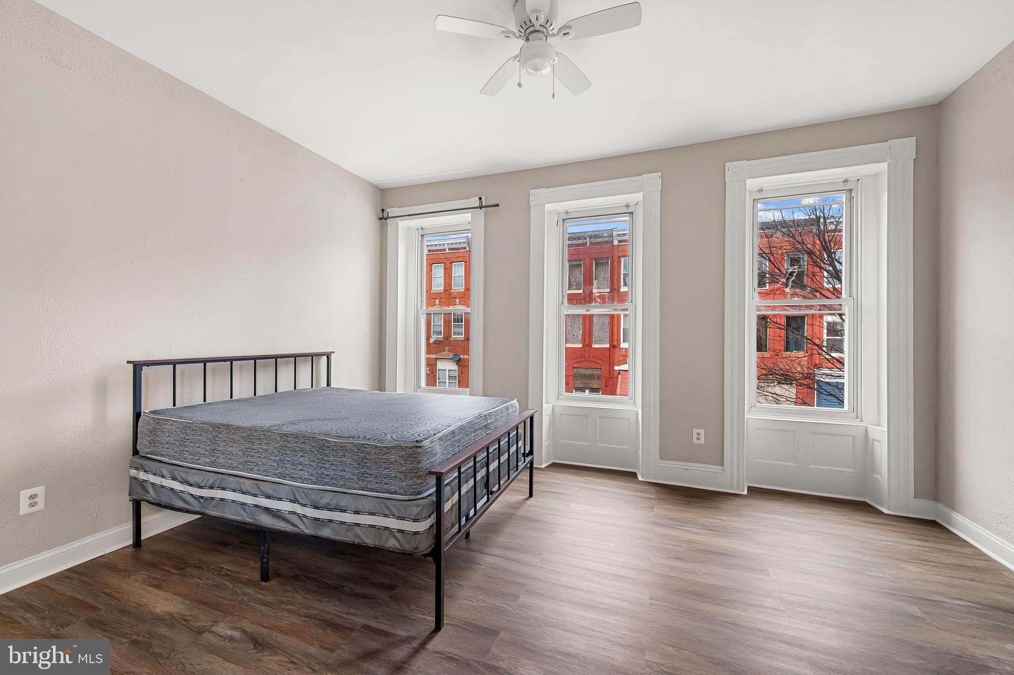 1005 Edmondson Avenue Baltimore, MD 21223 - Photo 24 of 45 a bedroom with a bed and wooden floor