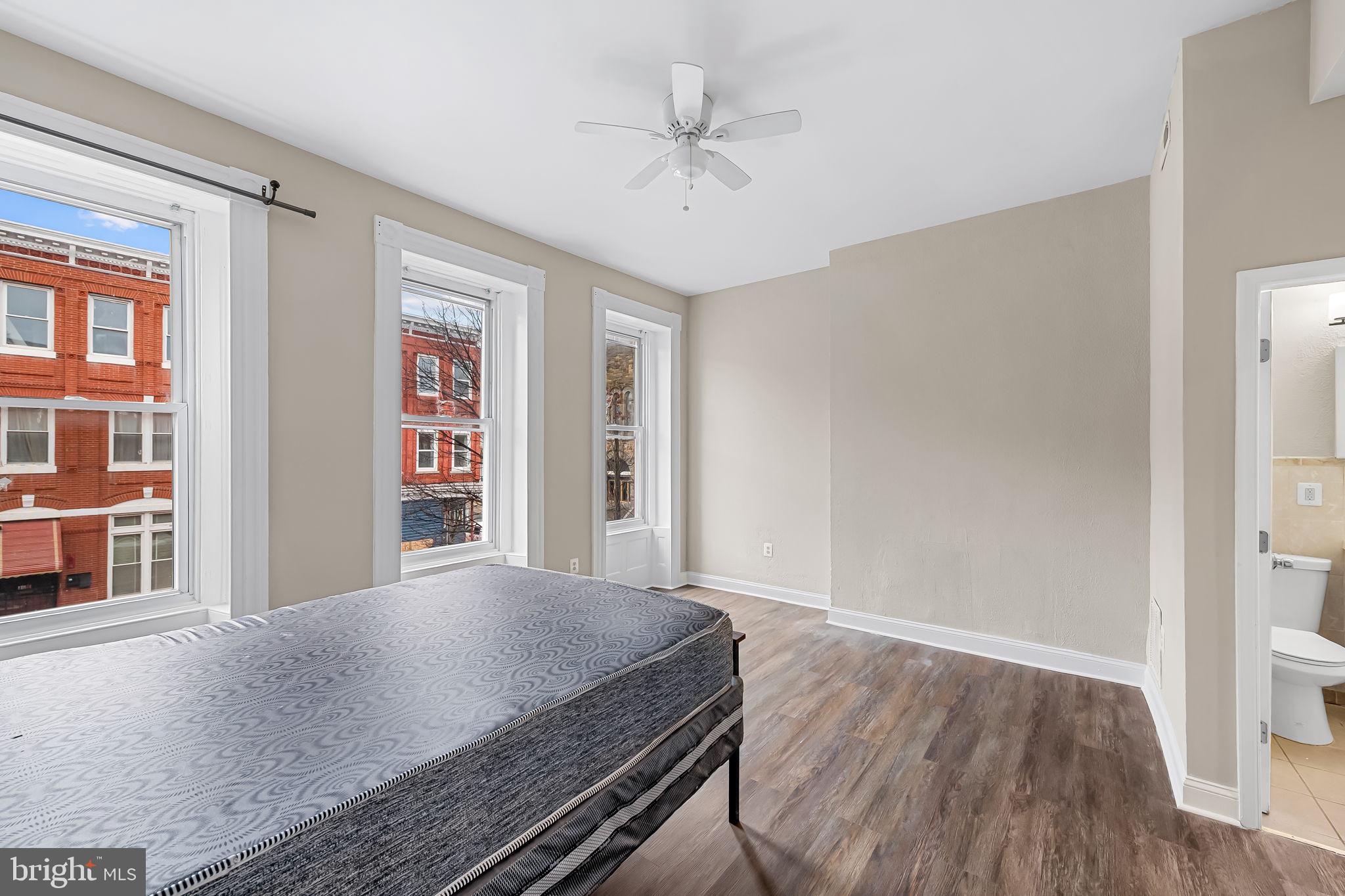 1005 Edmondson Avenue Baltimore, MD 21223 - Photo 25 of 45 a view of a livingroom with wooden floor and a ceiling fan