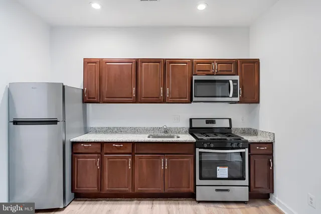 a kitchen with stainless steel appliances wooden cabinets and a refrigerator