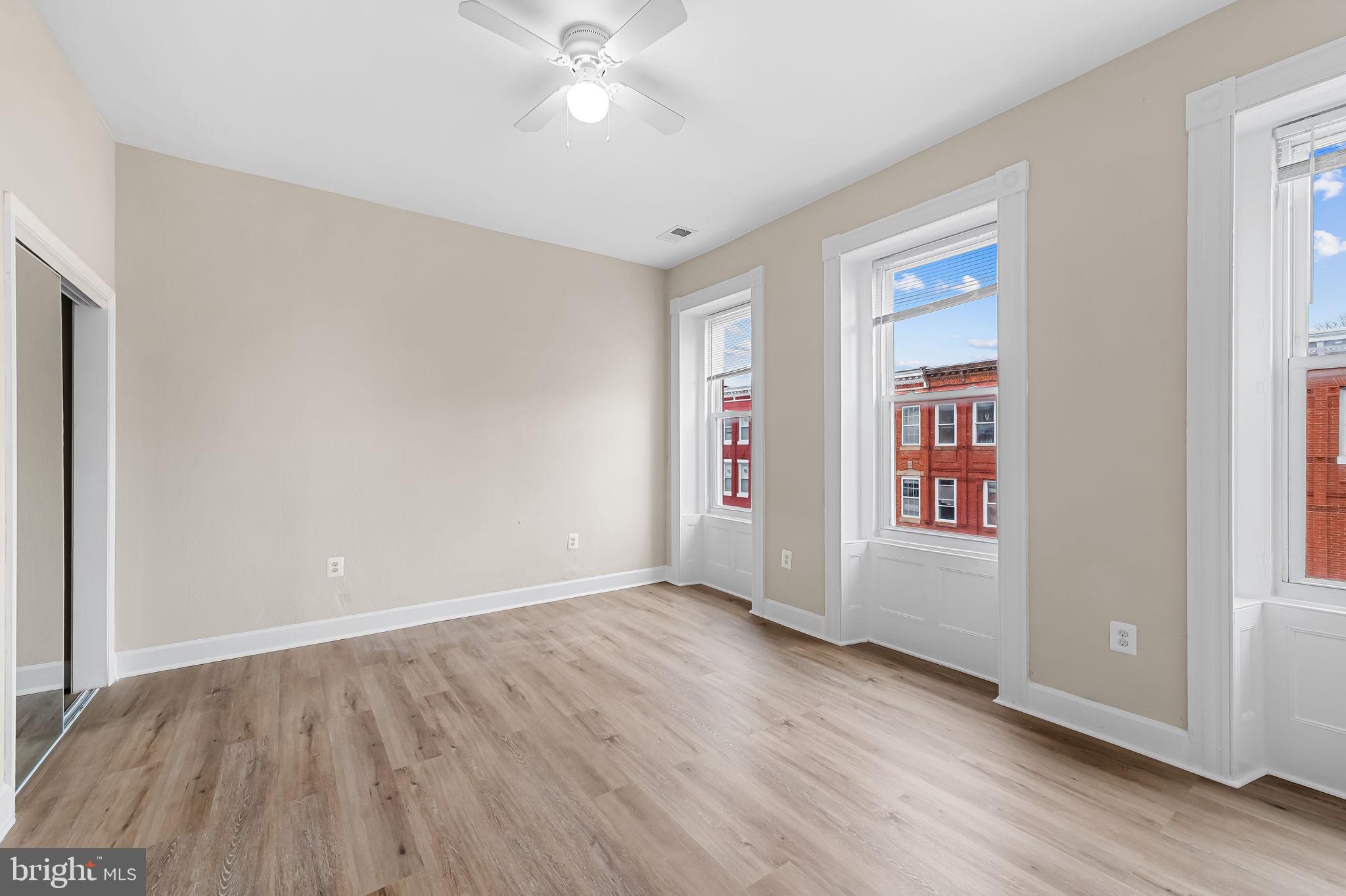 1005 Edmondson Avenue Baltimore, MD 21223 - Photo 41 of 45 an empty room with wooden floor and windows