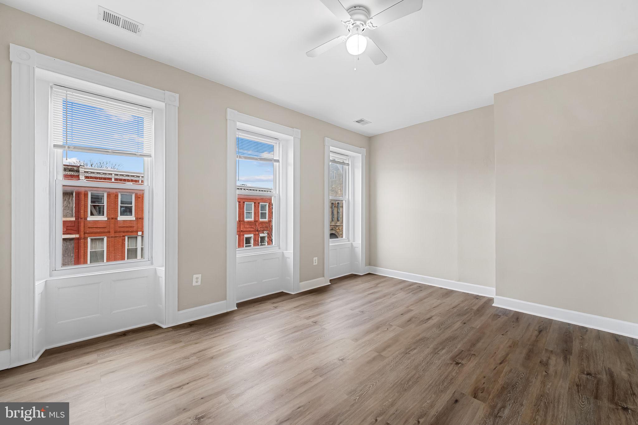1005 Edmondson Avenue Baltimore, MD 21223 - Photo 42 of 45 a view of an empty room with wooden floor and a window