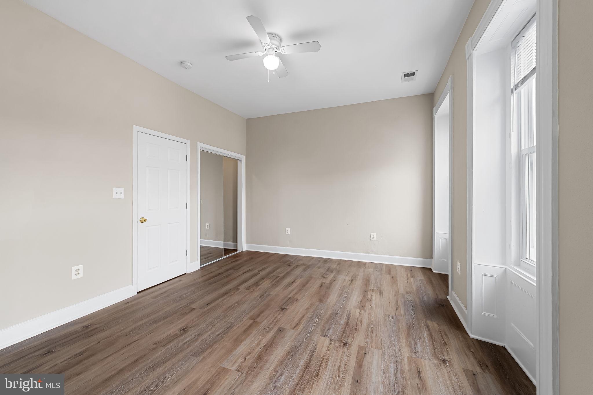1005 Edmondson Avenue Baltimore, MD 21223 - Photo 44 of 45 a view of an empty room with wooden floor and a window