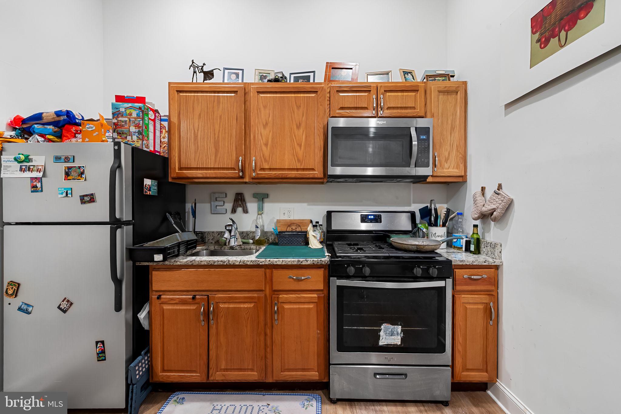 1005 Edmondson Avenue Baltimore, MD 21223 - Photo 5 of 45 a kitchen with stainless steel appliances granite countertop a stove and a refrigerator