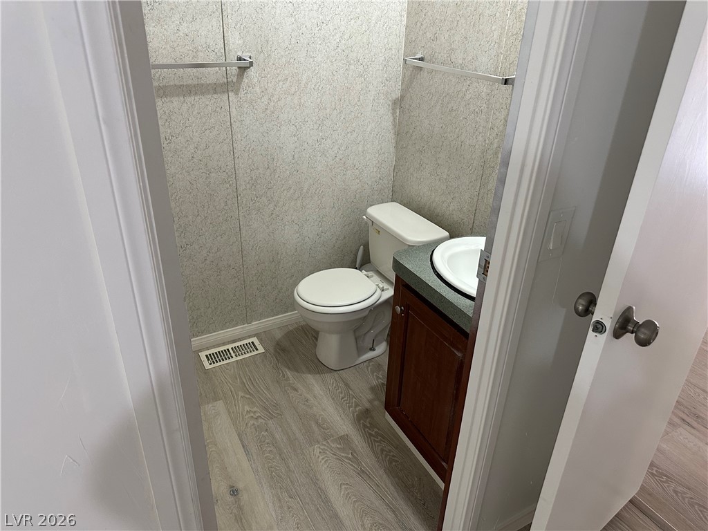 3270 West Simkins Road Pahrump, NV 89060 - Photo 23 of 36 Functional half bath featuring wood-look flooring and a compact vanity setup.