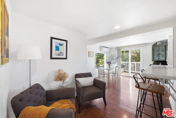 a living room with furniture wooden floor and a lamp
