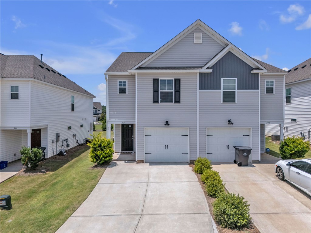 Clean lines and modern siding define this charming townhome with integrated garages and a manicured landscape.