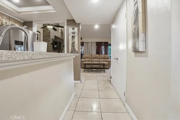 a living room with furniture a flat screen tv and kitchen view